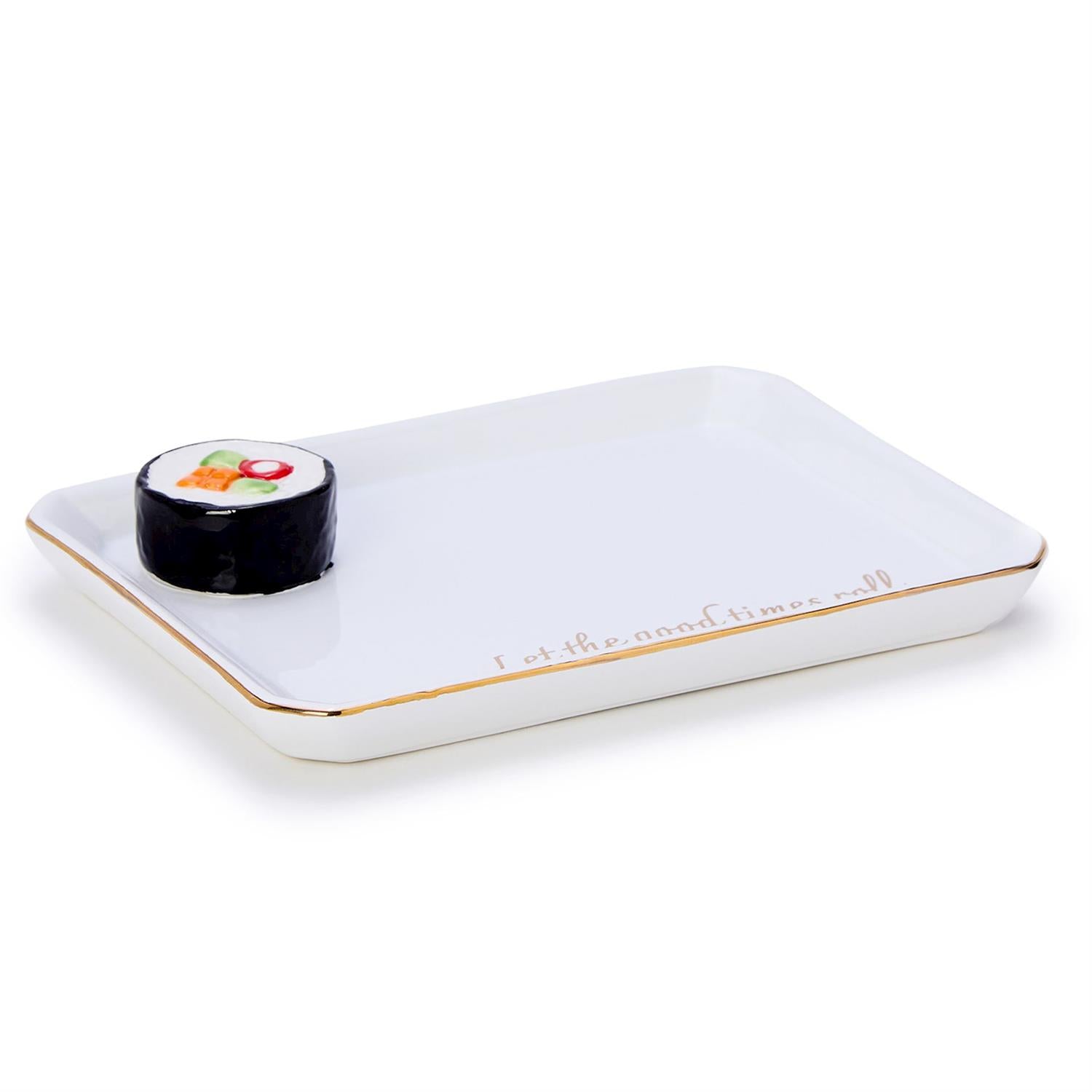 A white rectangular ceramic decorative tray with a gold rim and gold Let the good times roll script features a small black sushi-shaped candle with colorful red orange and green details on a clean white background