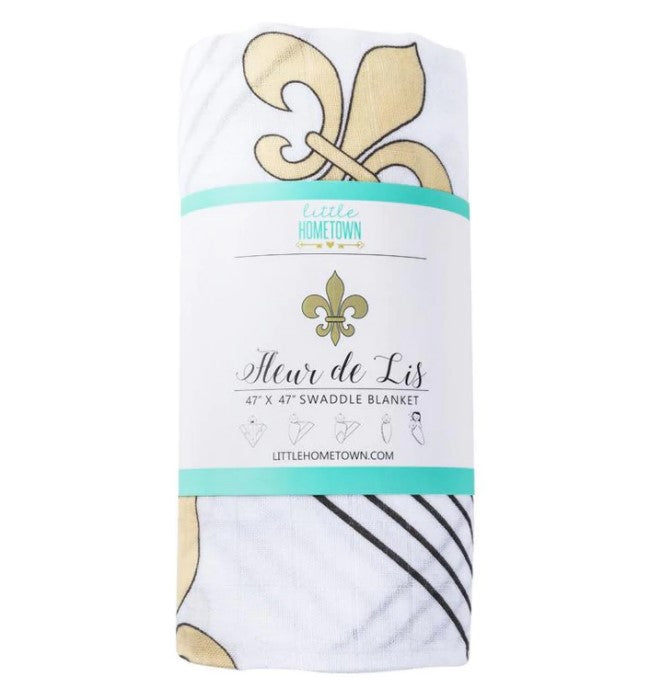 White swaddle blanket with gold fleur de lis pattern and black stripes wrapped in a Little Hometown product label