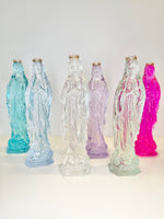 Six translucent resin statues of the Virgin Mary in various colors each wearing a small gold crown