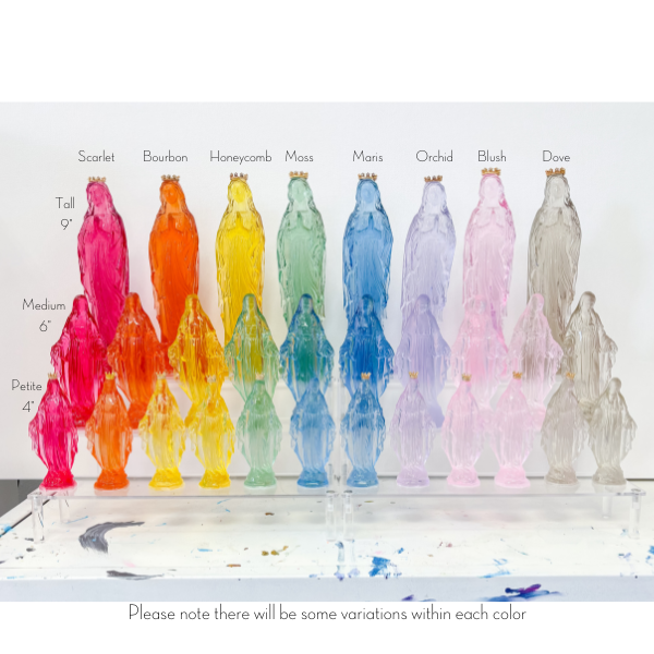 Collection of glass Virgin Mary statues in various colors and sizes arranged on a clear display stand