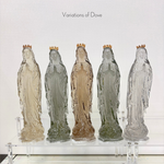 Five glass statues of the Virgin Mary in different shades with gold crowns on a clear acrylic stand