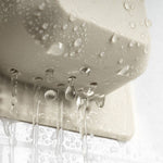 A macro photograph captures water cascading from a beige wall-mounted fixture, showcasing translucent spherical droplets and vertical liquid streams against a soft-focus textured surface