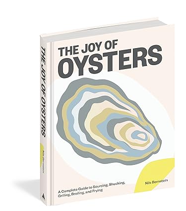 Cookbook cover by Nils Bernstein titled The Joy of Oysters displaying a modern stylized oyster graphic in pale blue, grey, and cream on a light pink background with the subtitle A Complete Guide to Sourcing, Shucking, Grilling, Broiling, and Frying