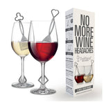 Product photography of two wine glasses, one holding white wine with a silver club-shaped The Wand purifier and the other red wine with a silver heart-shaped purifier, displayed alongside its white and grey product packaging stating "NO MORE WINE HEADACHES" and "REMOVES HISTAMINES & SULFITES"