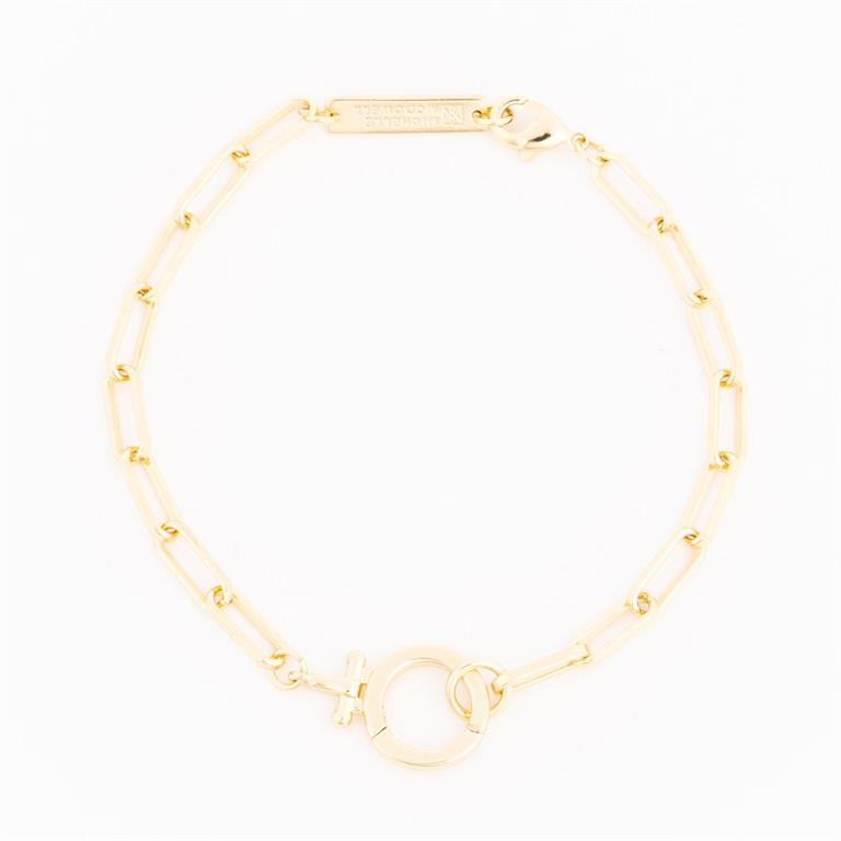 Gold bracelet by Michelle McDowell featuring a paperclip chain a prominent circular toggle clasp with a small female symbol charm and an engraved Michelle McDowell tag
