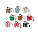 Collection of eight miniature bucket bags in various colors with gold padlocks and patterned silk ribbons