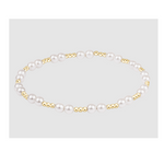Stretch bracelet featuring alternating white pearls and small gold beads