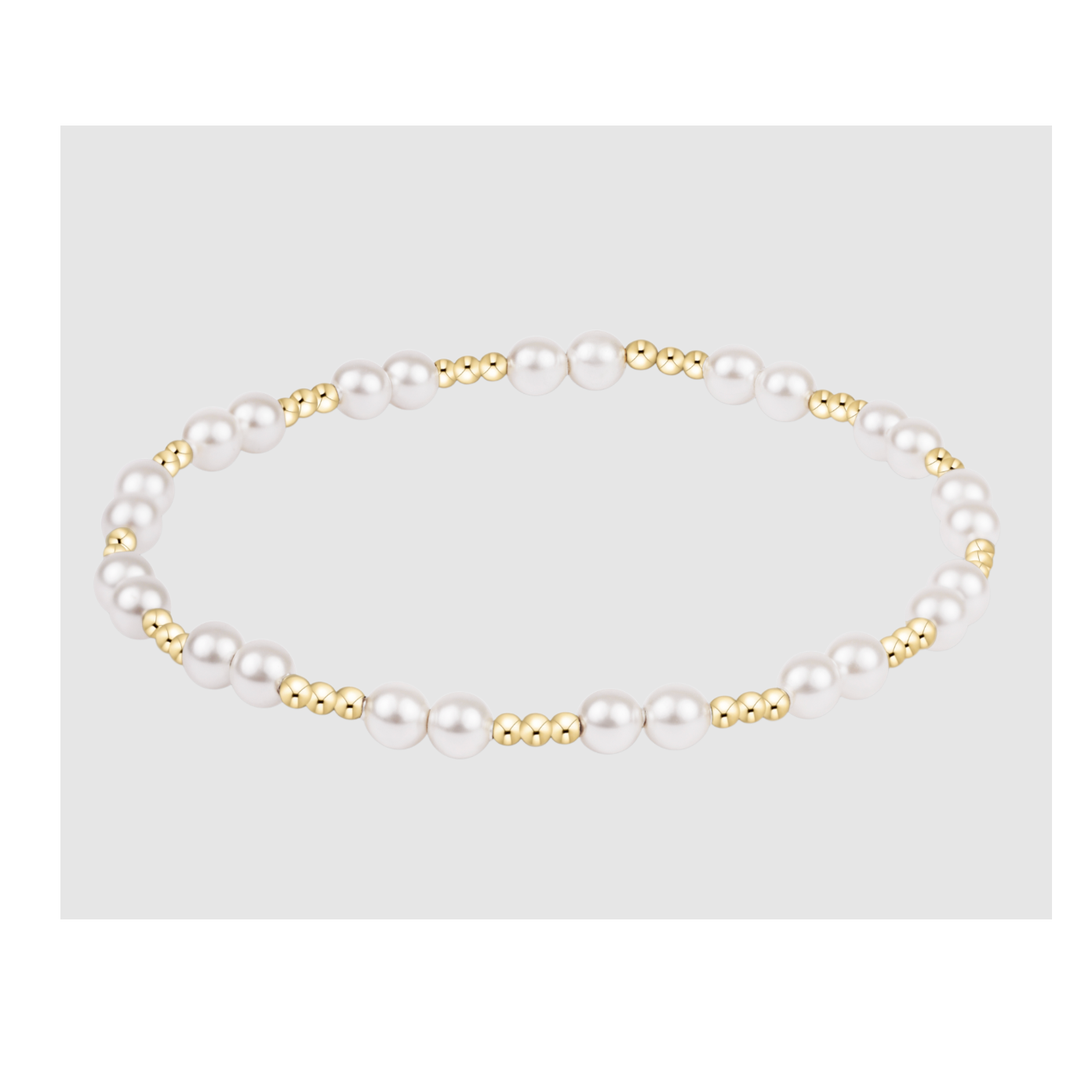 Stretch bracelet featuring alternating white pearls and small gold beads