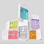 Stack of five colorful Touchland Power Mist hydrating hand sanitizer spray bottles