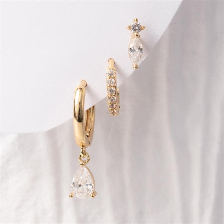 A set of three gold and crystal earrings featuring a large hoop with a dangling teardrop-shaped crystal a smaller pave-set hoop and a stud with a marquise and round crystal