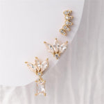 Gold-plated jewelry featuring a set of three clear cubic zirconia earrings including a floral marquise cluster with a baguette drop, a matching floral marquise cluster stud, and a curved marquise ear climber on a white background