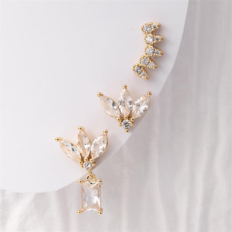 Gold-plated jewelry featuring a set of three clear cubic zirconia earrings including a floral marquise cluster with a baguette drop, a matching floral marquise cluster stud, and a curved marquise ear climber on a white background