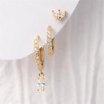 Digital photography of a set of three gold-toned earrings on a white background, including a sparkling crown-shaped stud, a pavé-set hoop, and a hoop with a dangling marquise-cut cubic zirconia drop