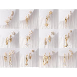 Gold earrings collection showcasing a variety of gold-toned hoop, stud, and dangle earrings with sparkling clear gemstones, featuring star, crescent moon, and heart designs displayed on white backgrounds