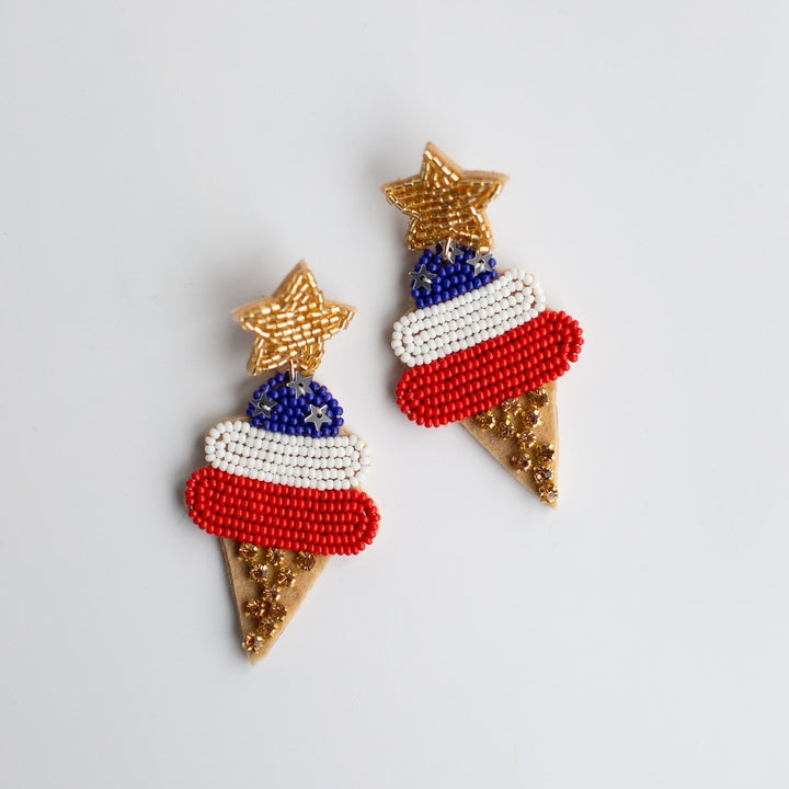 Beaded earrings of patriotic red white and blue ice cream cones featuring gold beaded star tops gold sparkle cone bases and tiny silver stars on the blue beaded section against a white background