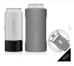 BrüMate product photography featuring a white Hopsulator Slim can cooler on a black screw-on base, a taller gray insulated can cooler, and a separate clear leakproof lid with a gray flip-top closure, all part of the MÜV Collection displayed on a white background