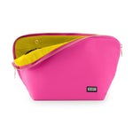 Product photography KUSSHI hot pink travel bag featuring a vibrant lime green interior lining partially unzipped with gold hardware and a black brand logo