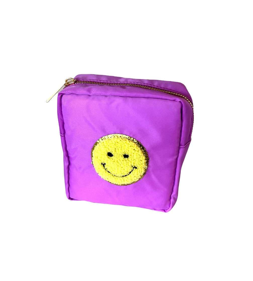 Purple boxy pouch bag featuring a vibrant gold sequin smiley face applique and a prominent gold zipper