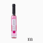 A slender glass bottle of pink mixture hypoallergenic bubble bath with a black wax seal top and a white label featuring "22" and "vat 