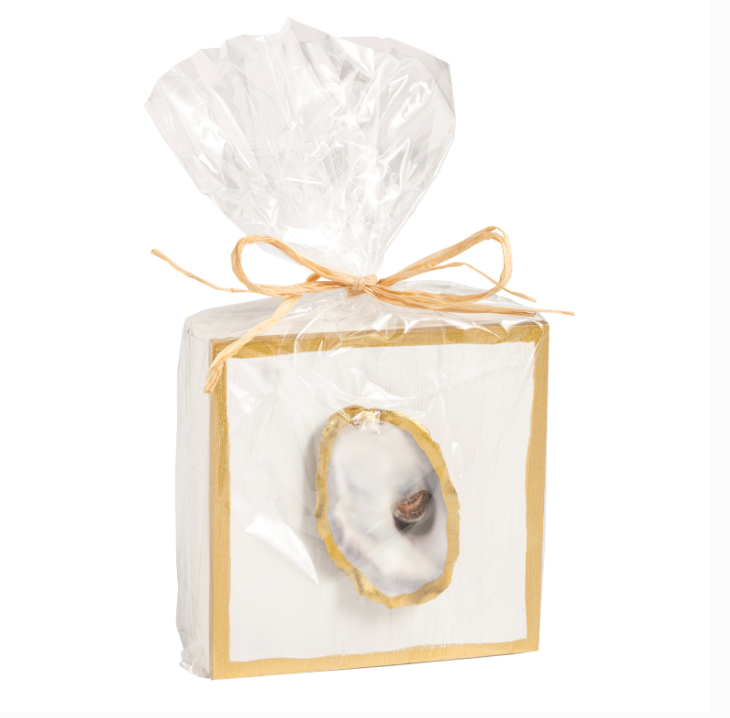 Square white wooden block with gold trim and oyster shell accent in clear gift bag with raffia bow