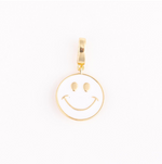 Gold-toned metal and white enamel circular smiley face charm with gold eyes and upturned mouth detail