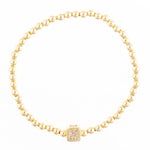Gold beaded bracelet with a square charm featuring the letter M in crystals