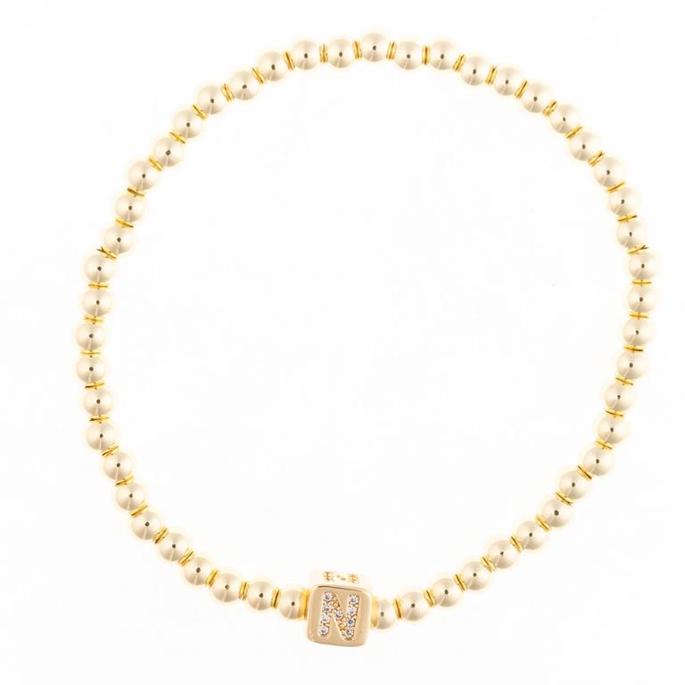 Gold bead bracelet with a central square charm featuring the letter N in crystals