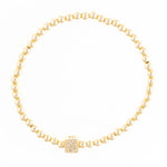 Gold beaded stretch bracelet with a square charm featuring a diamond letter S