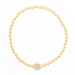 Gold beaded stretch bracelet with a square charm featuring the letter W in pave crystals