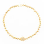 Gold beaded stretch bracelet with a square charm featuring the letter F in crystals