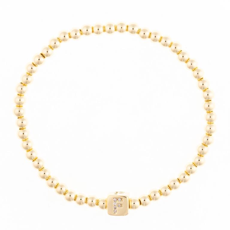 Gold beaded stretch bracelet with a square charm featuring the letter F in crystals