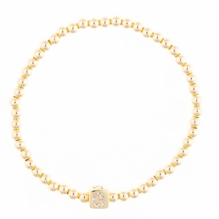 Gold beaded stretch bracelet with a square charm featuring a diamond letter G