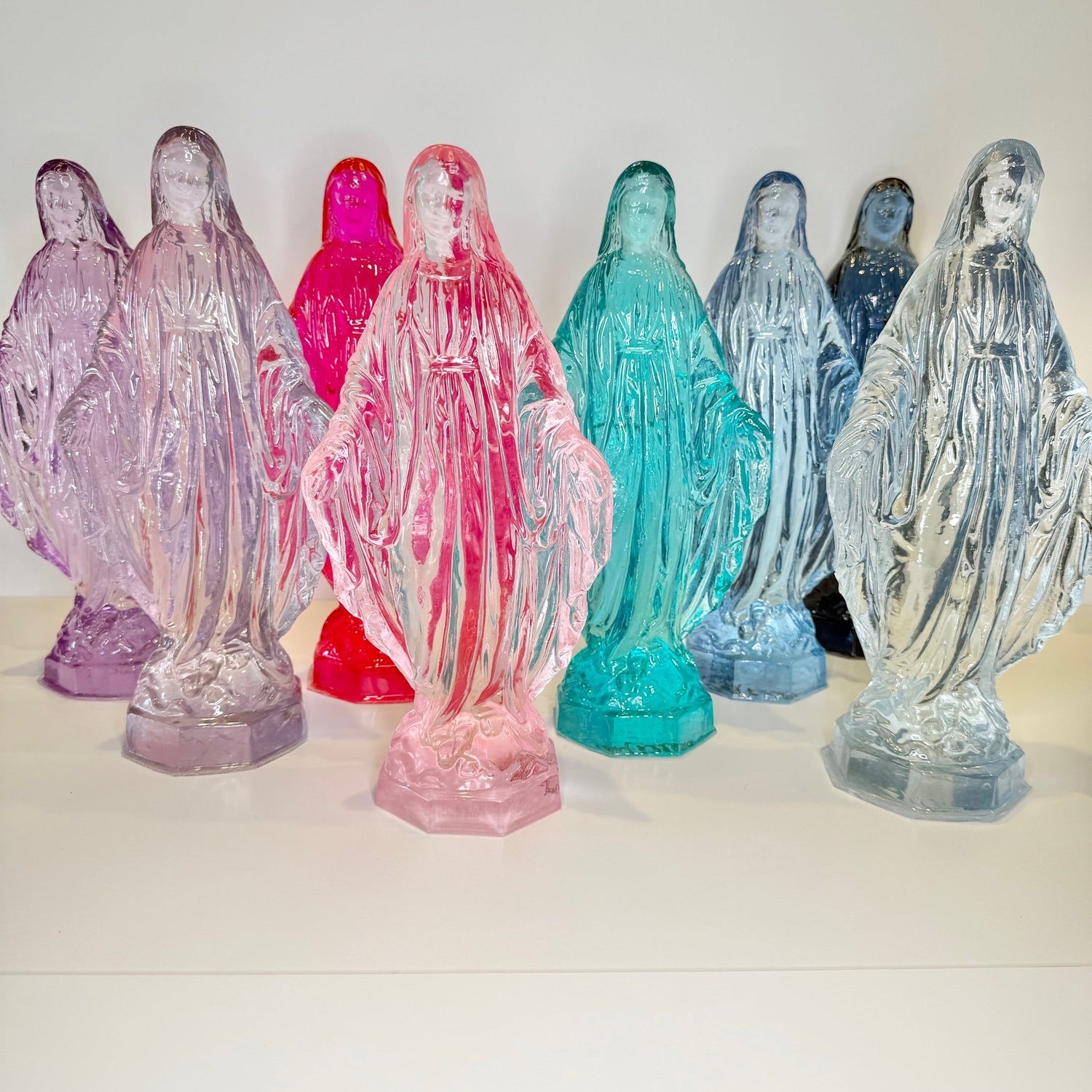 Colorful statues of a religious figure on a white background