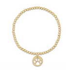 Gold beaded stretch bracelet with a circular charm featuring a cutout paw print