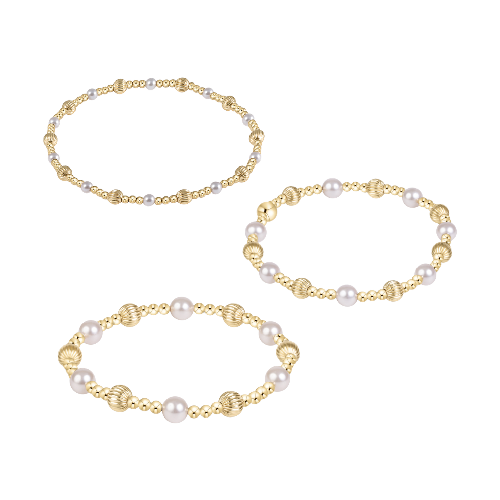 Three stretch bracelets featuring alternating gold beads and white pearls