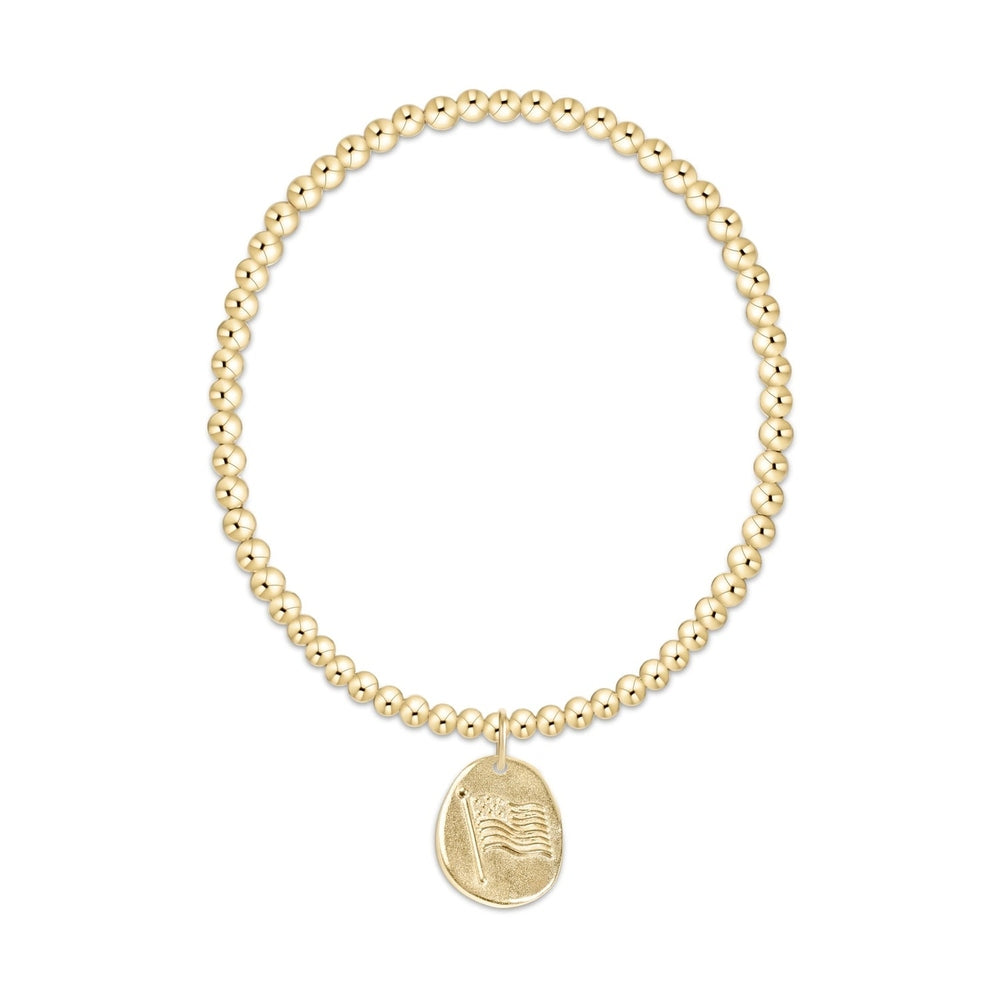 Gold beaded stretch bracelet with a round charm featuring an embossed American flag