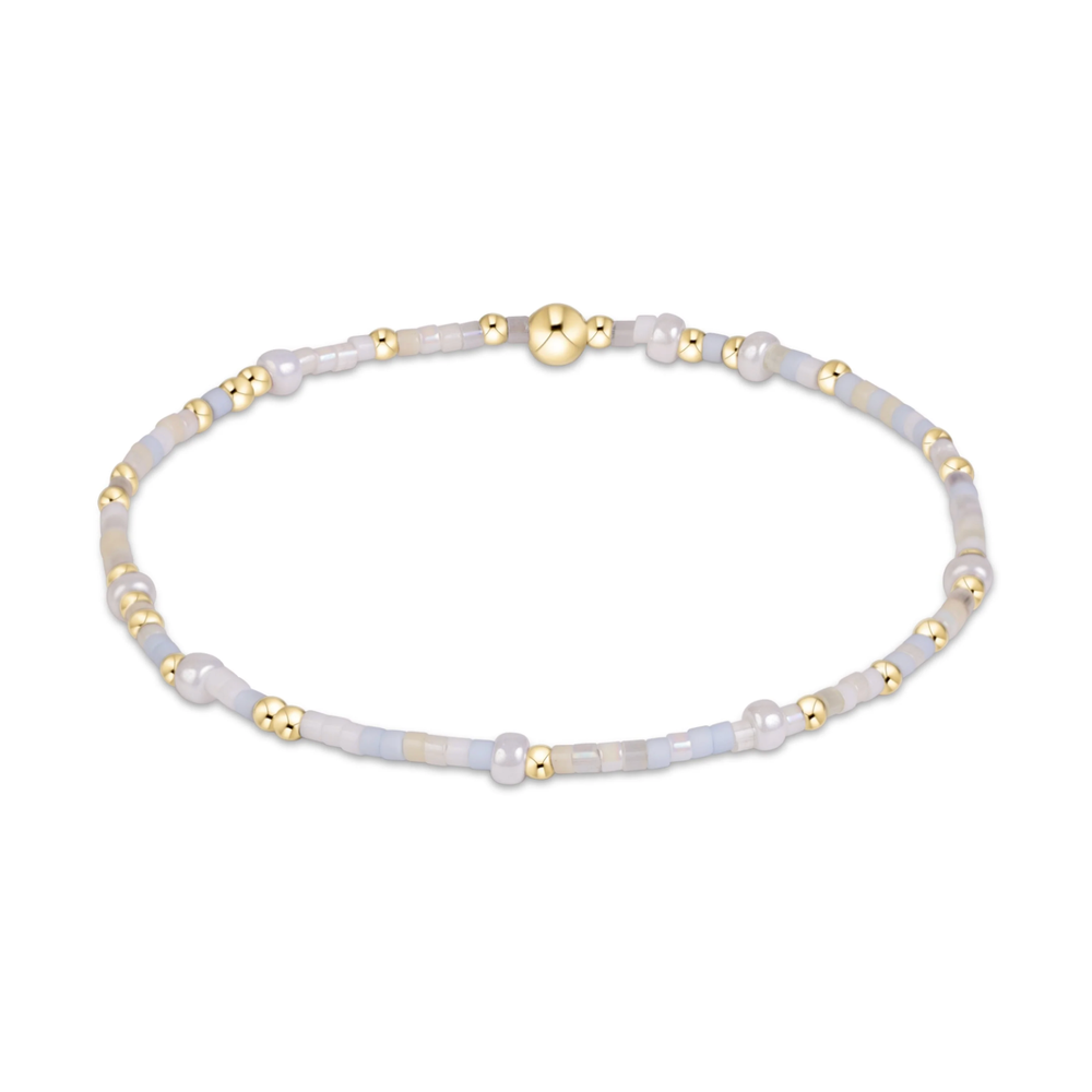 White and pale gray mixed seed bead stretch bracelet with gold accents