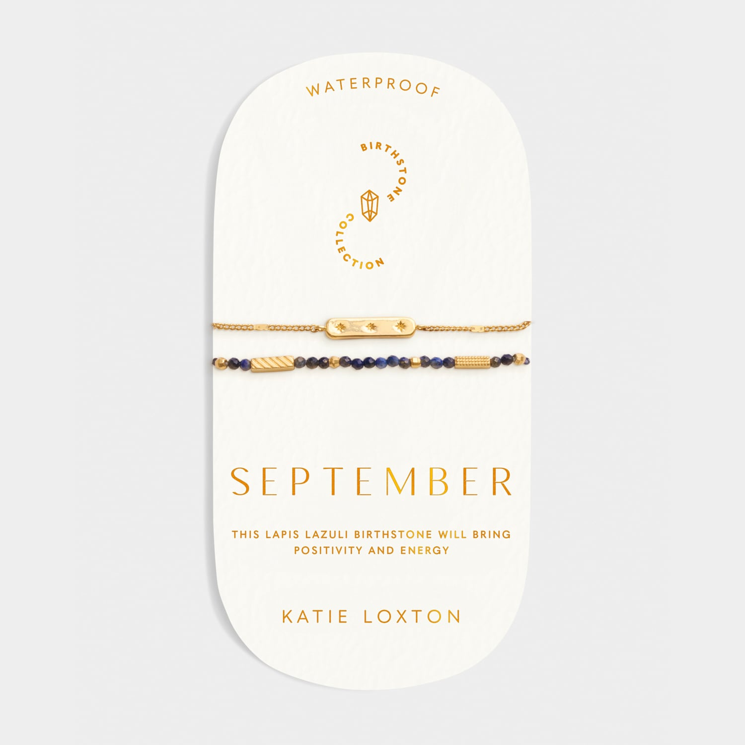 Two gold chain and lapis lazuli bead bracelets on a September birthstone display card