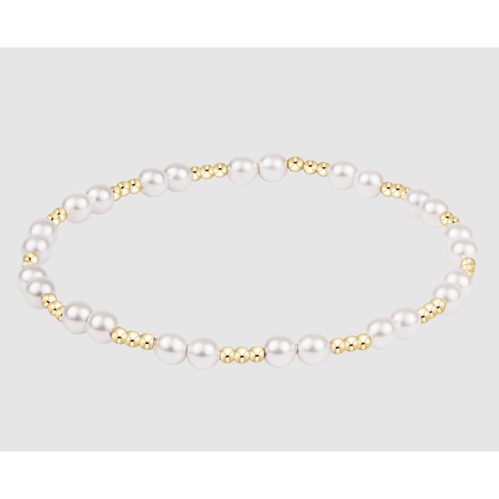 Stretch bracelet featuring alternating white pearls and small gold beads