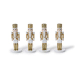 Four white and gold glitter nutcracker place card holders in a row