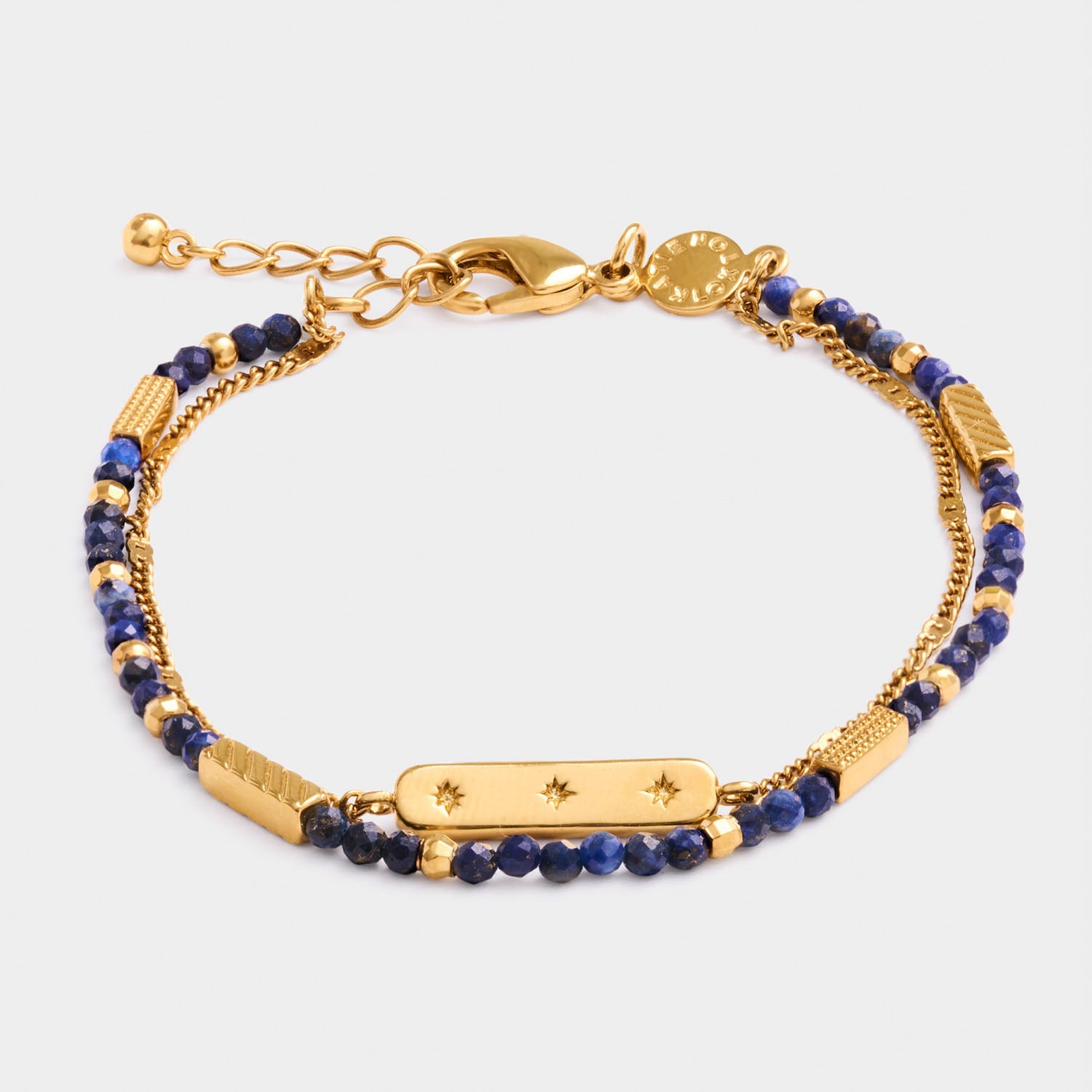 Gold chain bracelet with blue lapis lazuli beads and a central bar charm with star engravings