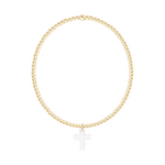 Gold beaded stretch bracelet with a silver cross charm
