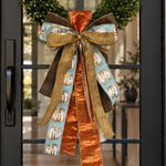 Layered bow of copper, gold mesh, brown velvet and aqua pumpkin-print ribbon on a boxwood wreath