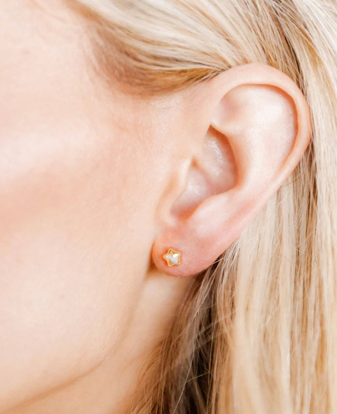 Model wearing a gold star screwback stud