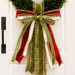 Bow of red velvet, olive green, ivory and gold tinsel ribbons with long tails on a boxwood wreath