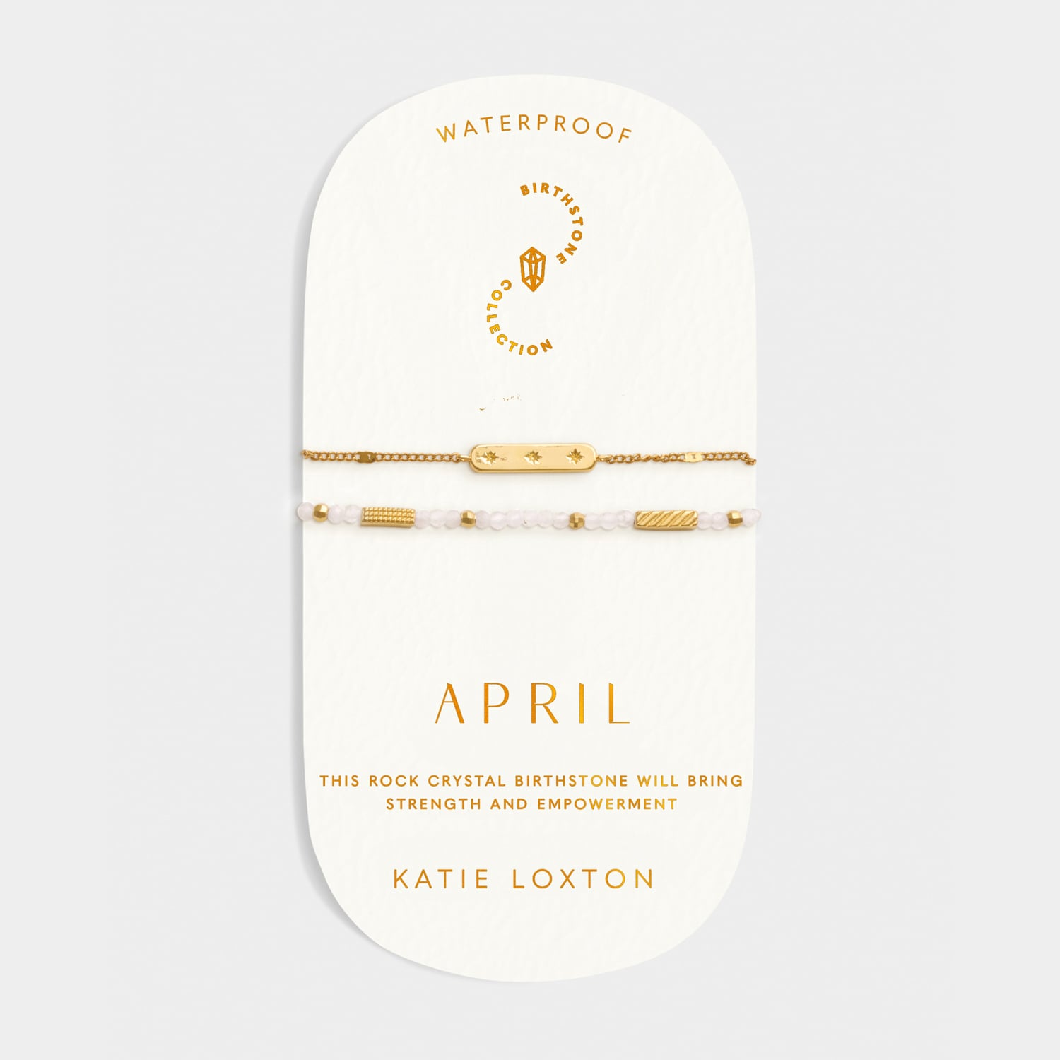Two gold tone bracelets on a display card labeled April with rock crystal birthstone details