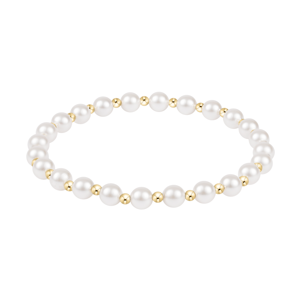Stretch bracelet featuring alternating white pearls and small gold beads