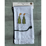White tea towel with gold and green tassels in its package