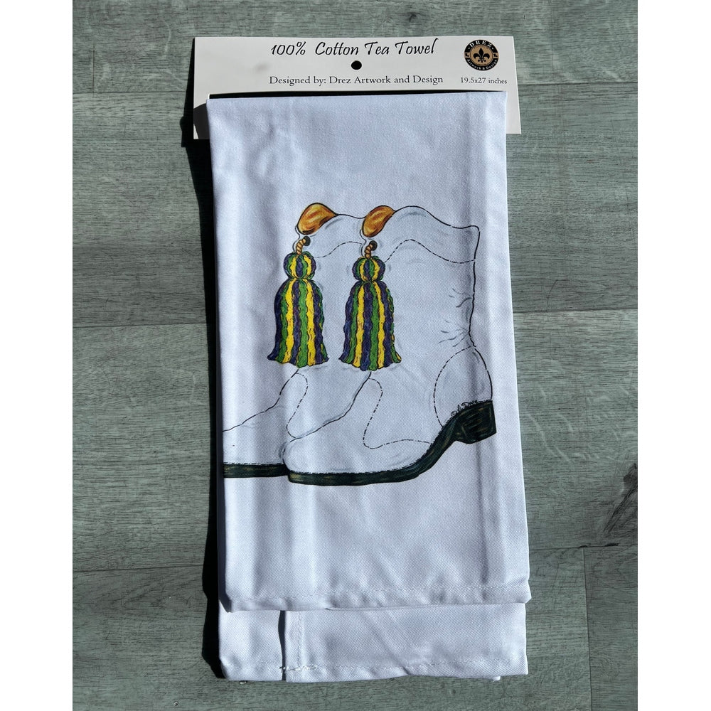 White tea towel with gold and green tassels in its package