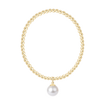 Gold bead necklace with a single white pearl pendant